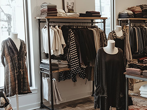 Image of black and white dresses and shirts hanging up in a retail store